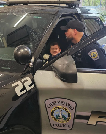 Chelmsford Police Officer Cory D'Entremont shows 6-year-old Tyler Bolger around the inside of a police cruiser during Tyler's visit to the police station with his family. Cops for Kids with Cancer and the Chelmsford Police presented Tyler and his family with $5,500 to help support their ongoing battle with cancer.